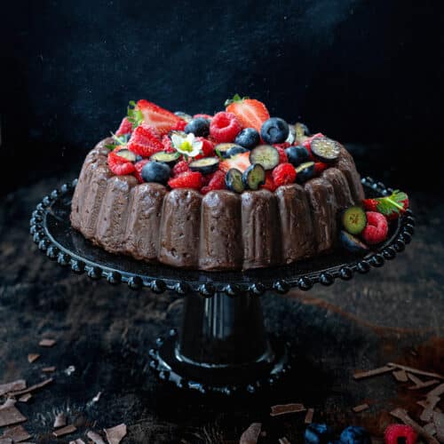 Chocolate almond cake topped with chocolate ganache and a medley of fresh berries