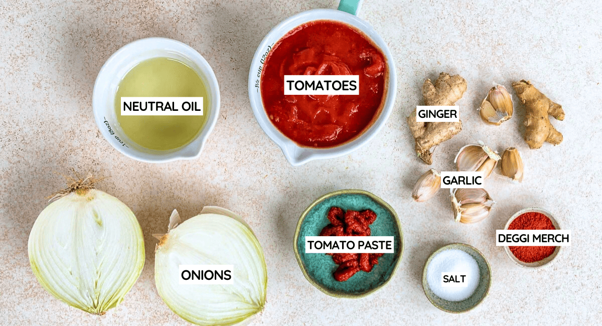 Ingredients for a flavourful Masala Sauce are arranged on a light surface, including neutral oil, tomatoes, ginger, garlic, halved onions, tomato purée, red chilli powder labelled deggi mirch, and salt.