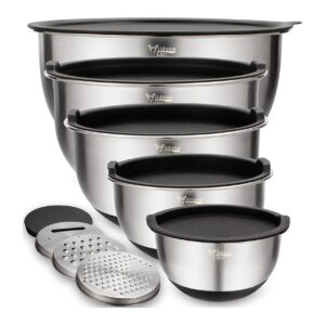 A set of five stainless steel mixing bowls with black lids, stacked inside each other, alongside three metal grater attachments. The largest bowl is at the back, and the bowls decrease in size toward the front.