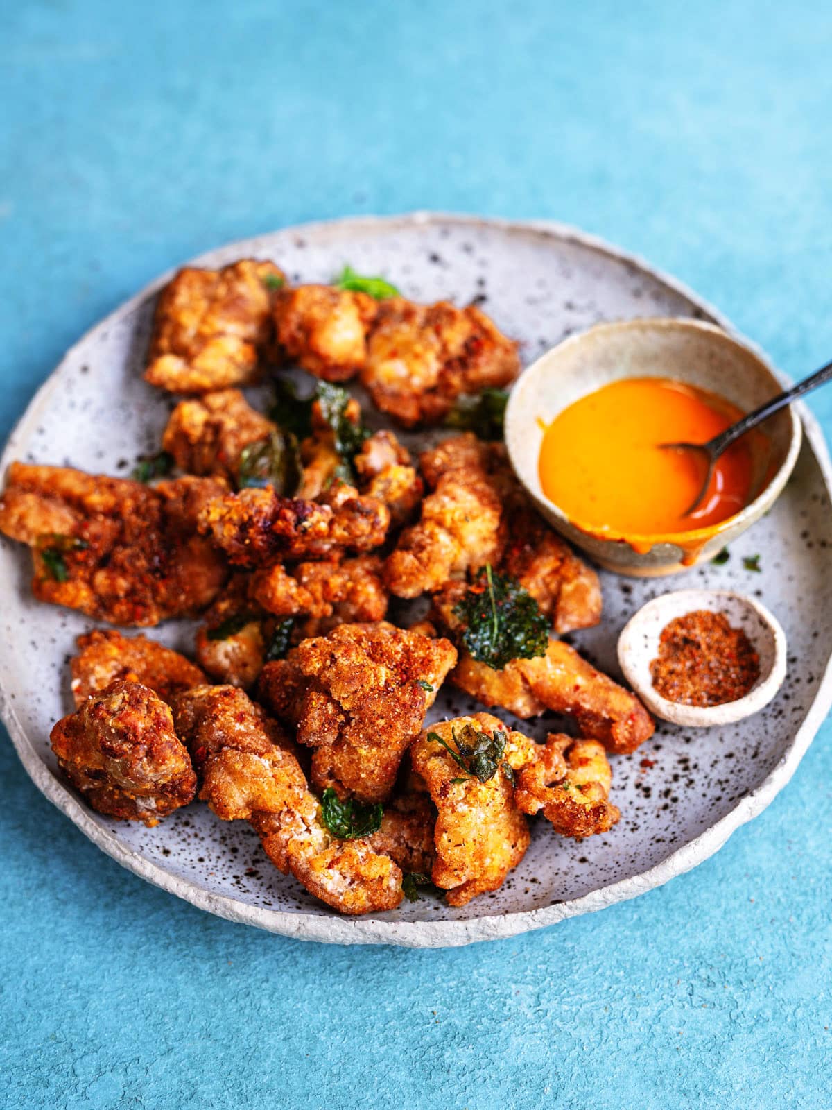 Taiwanese fried chicken served with a dipping sauce and a dish of five spice seasoning powder